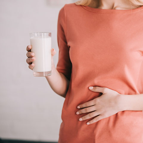 Donna incinta con bicchiere di latte in mano