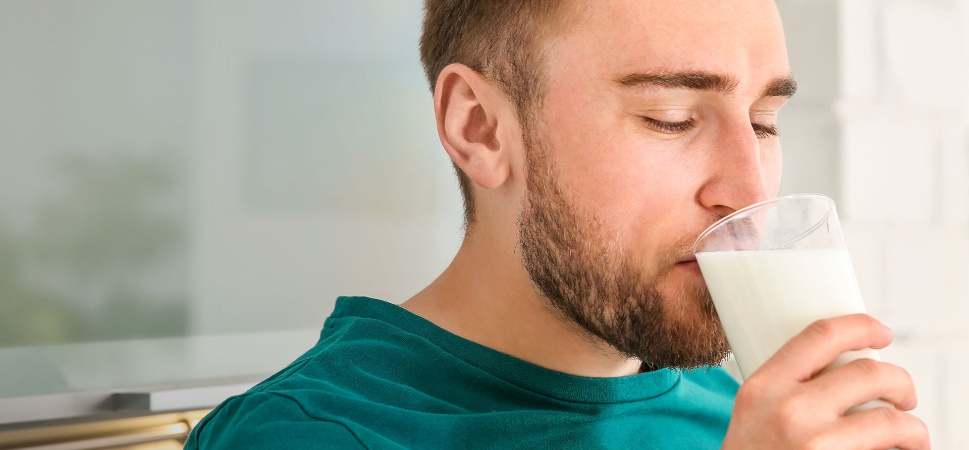 Uomo che beve un bicchiere di latte