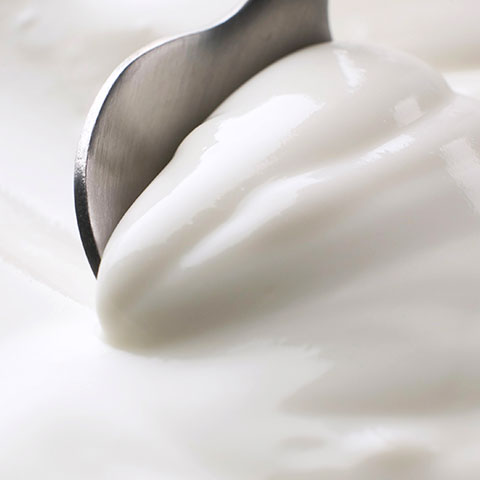 Cucchiaio che affonda nello yogurt