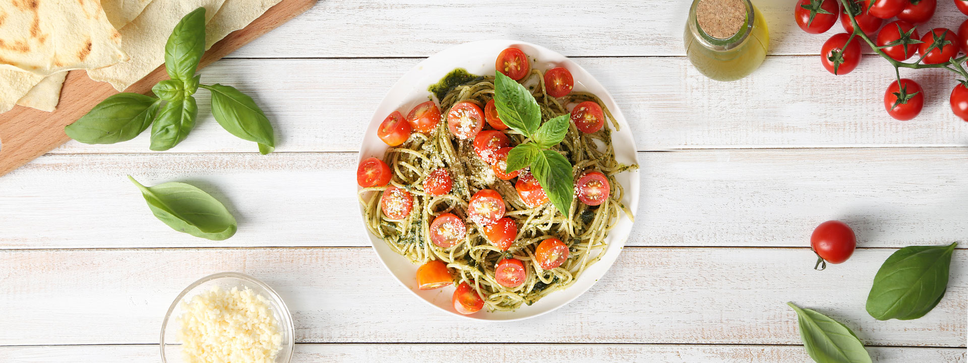 Piatto di spaghetti con pesto e pomodorini visto dall'alto