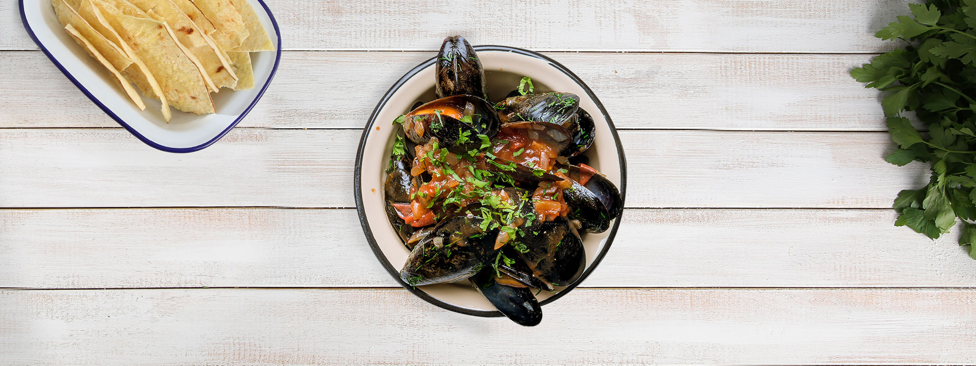 Piatto di zuppa di cozze visto dall'alto su tavolo