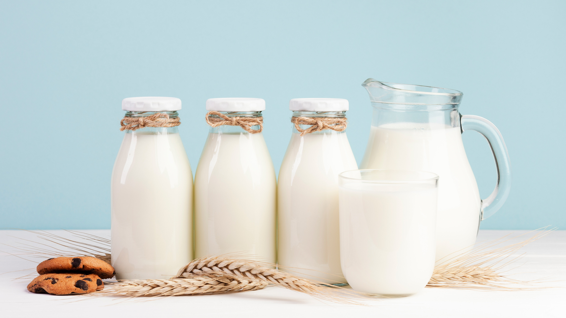 Bottiglie e caraffa di latte fresco