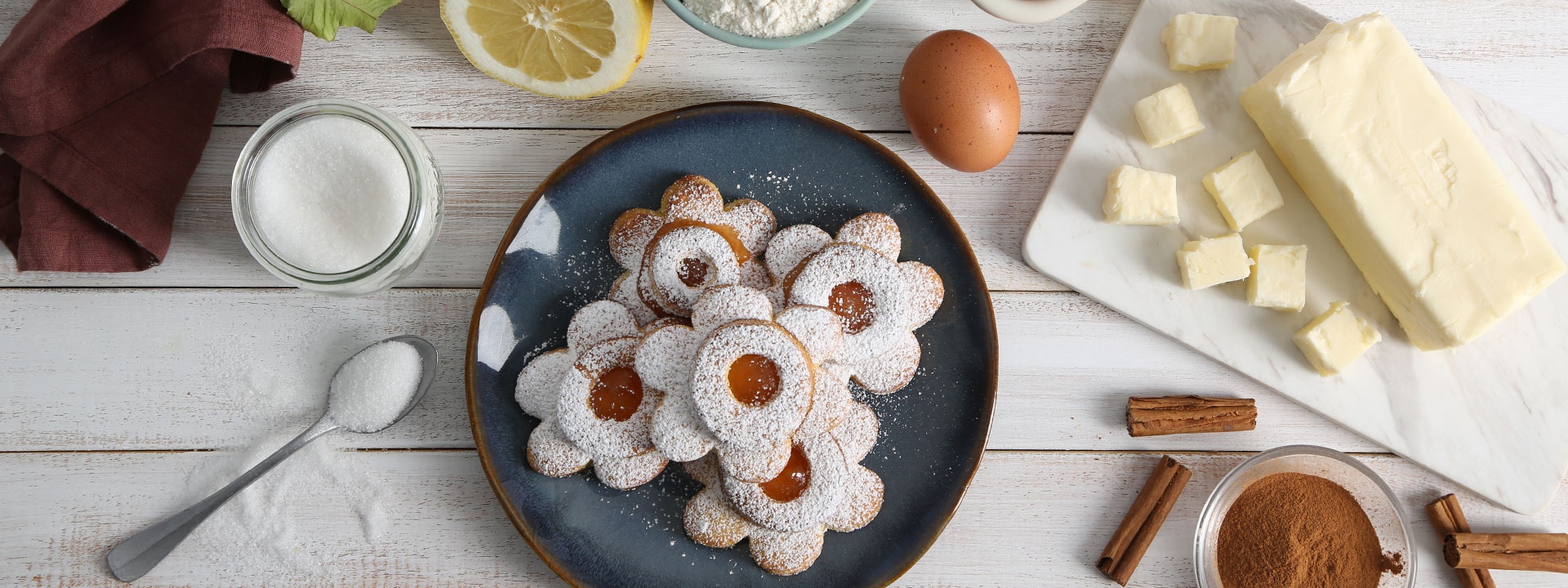 Tavola con piatto di biscotti ripieni alla marmellata a forma di fiore
