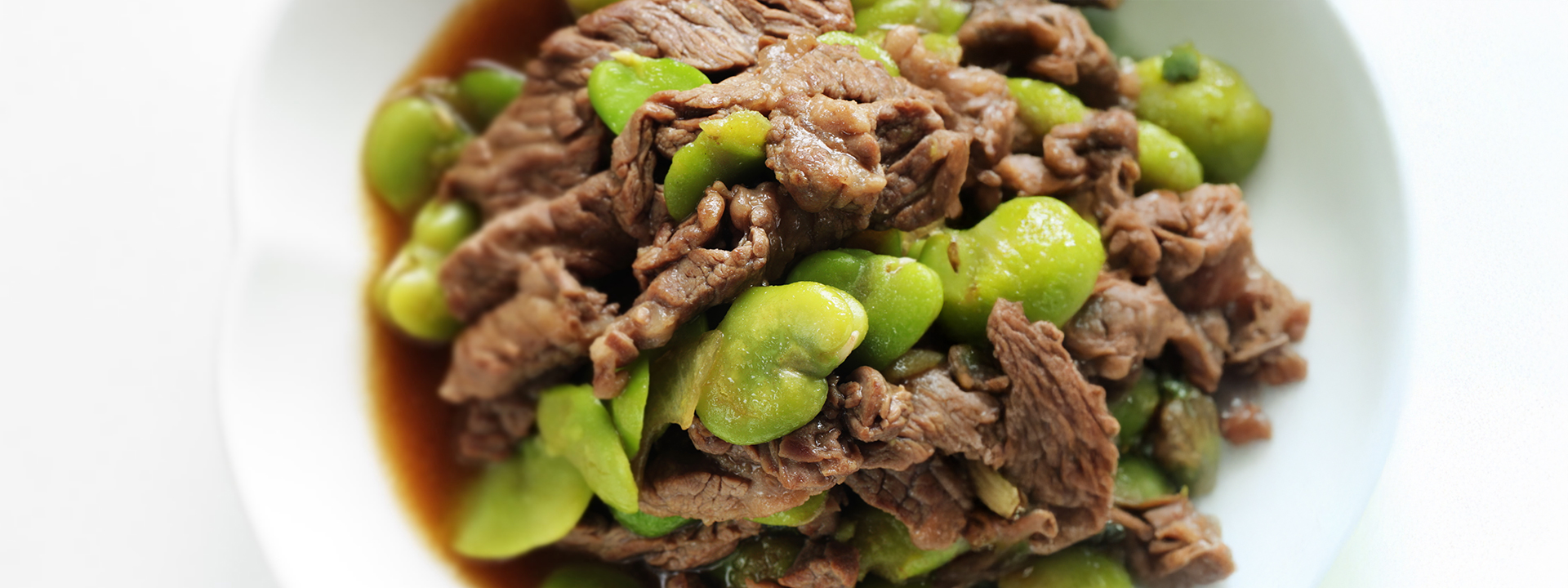 Zoom su piatto di carne e fave fresche