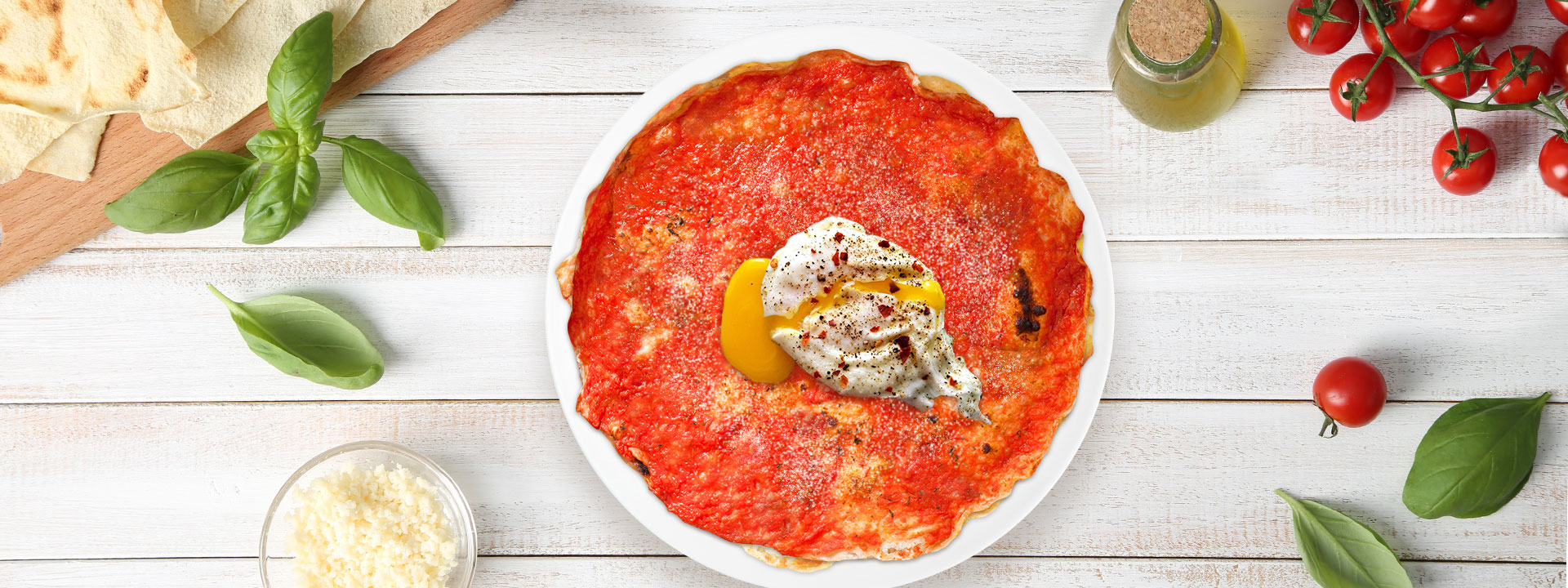 Piatto di pane frattau con pomodoro e uova in camicia su tavola apparecchiata