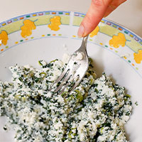 forchetta che mescola ricotta e spinaci per impasto