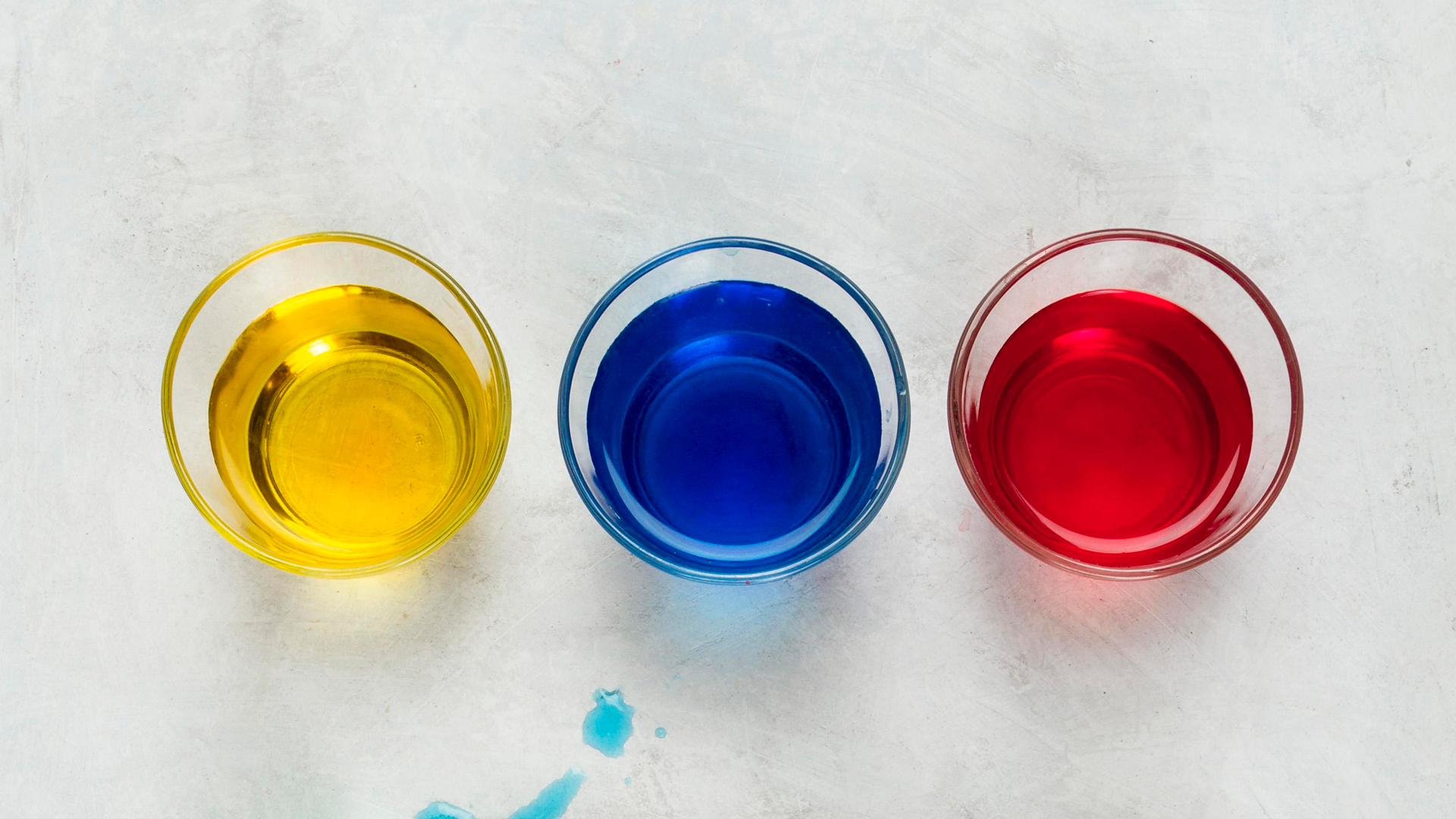 tre bicchieri con colorante sciolto in acqua
