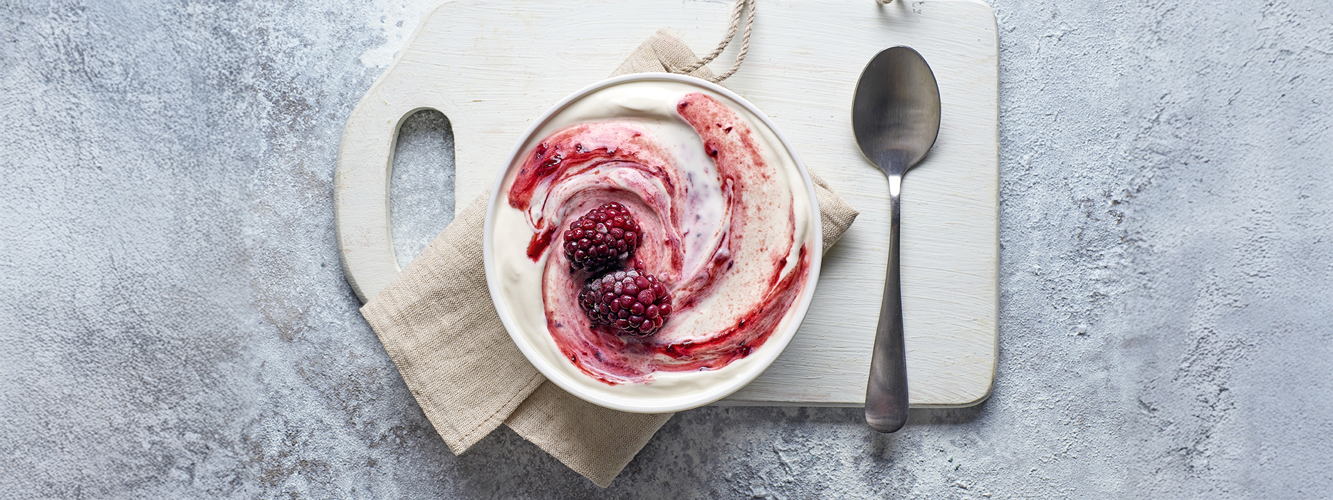 Ciotola di mousse allo yogurt con lamponi, su tagliere vista dall'alto