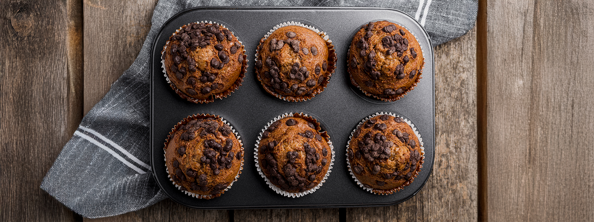 6 muffin integrali con gocce di cioccolato nello stampo, vista dall'alto