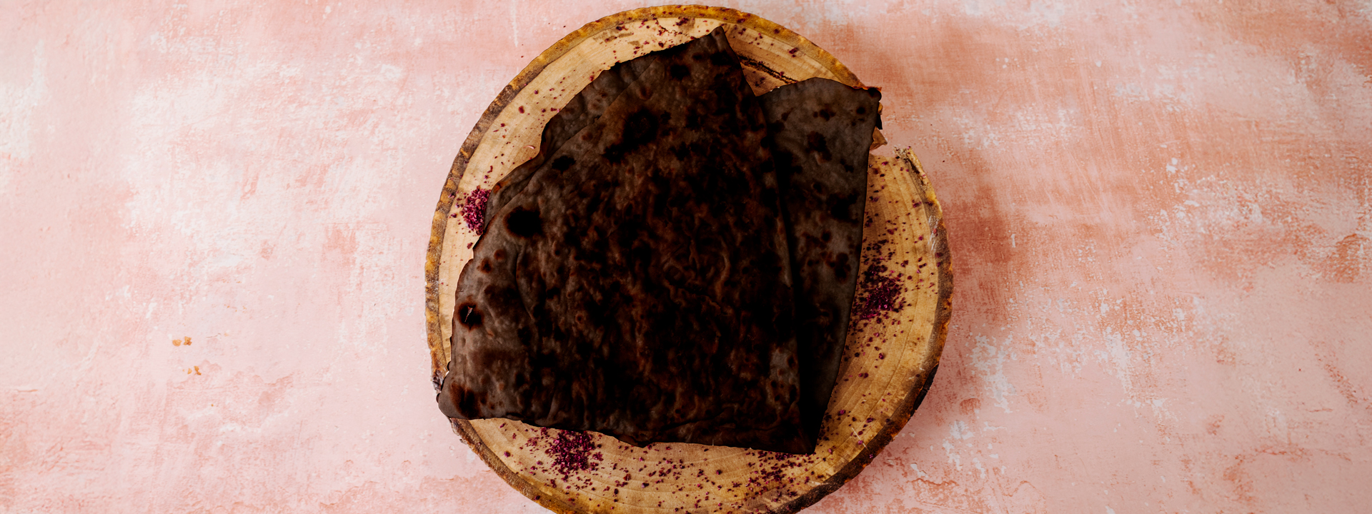 Tagliere di legno con pane casarau nero